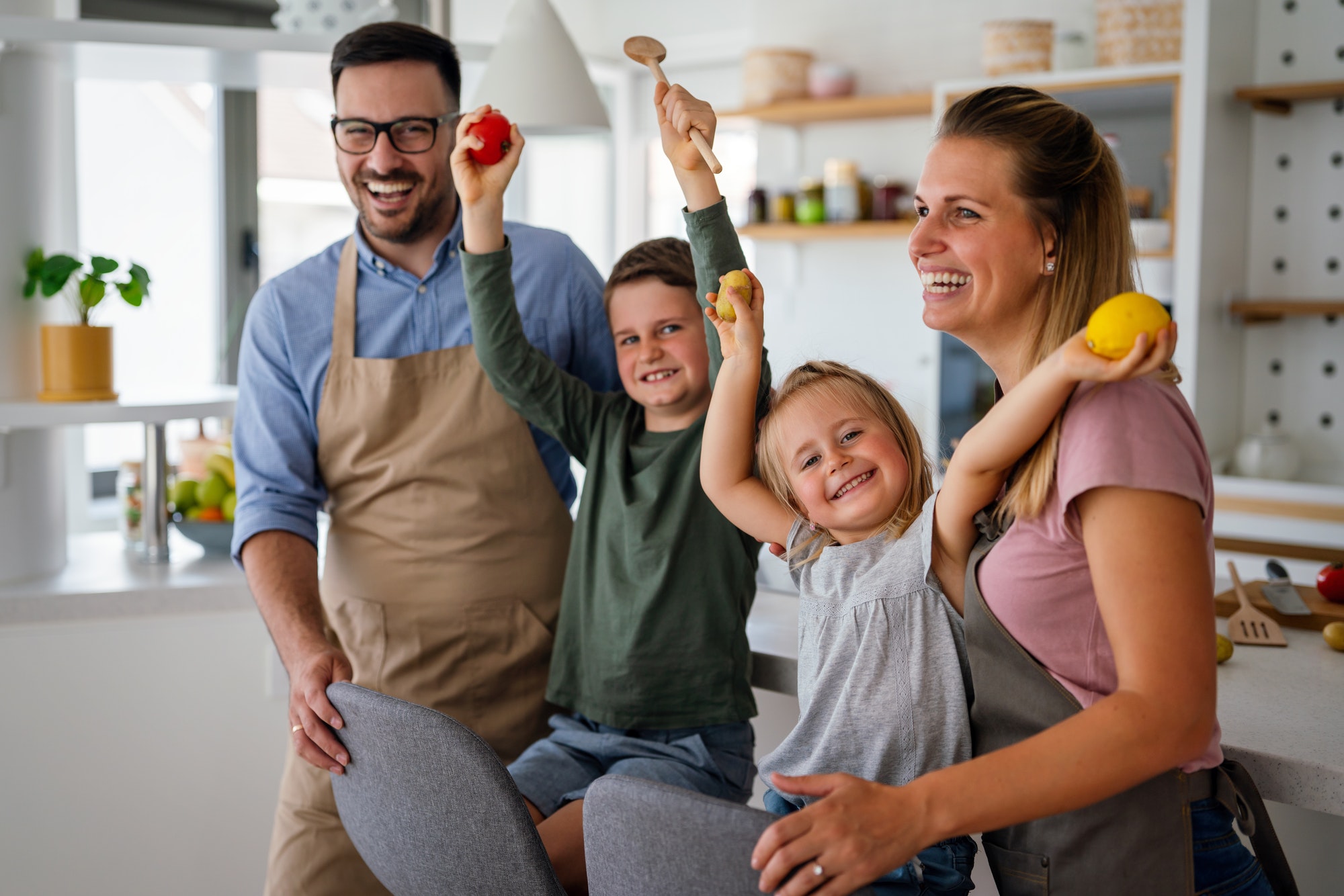 Happy family preparing healthy food together in kitchen. People happiness cooking concept